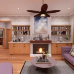 Interior of a cozy 3-bedroom cottage living area featuring modern lavender sofas, a warm glowing fireplace with a wood mantel, and light wood built-in cabinetry. The room is decorated with patterned wallpaper, mustard yellow curtains, and a large dark wood ceiling fan over hardwood floors.