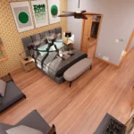 Modern cottage bedroom with patterned yellow wallpaper, green geometric wall art, a grey upholstered bed, and a small sitting area by the window